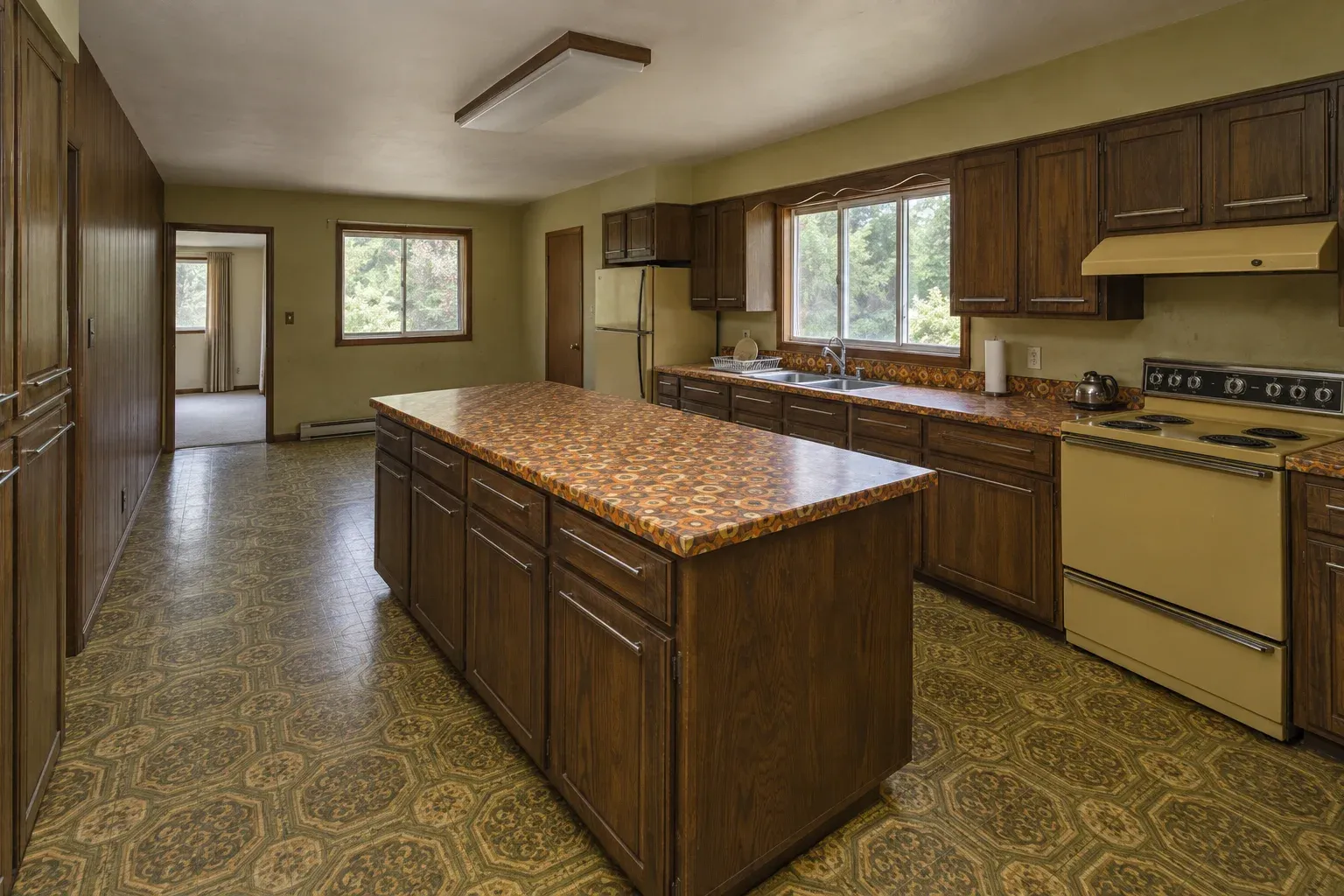 Dark oak kitchen with a patterned vinyl floor and a laminate island before remodeling